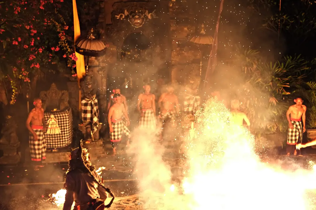 Performers around a ring of fire during a Balinese Kecak fire dance at dusk